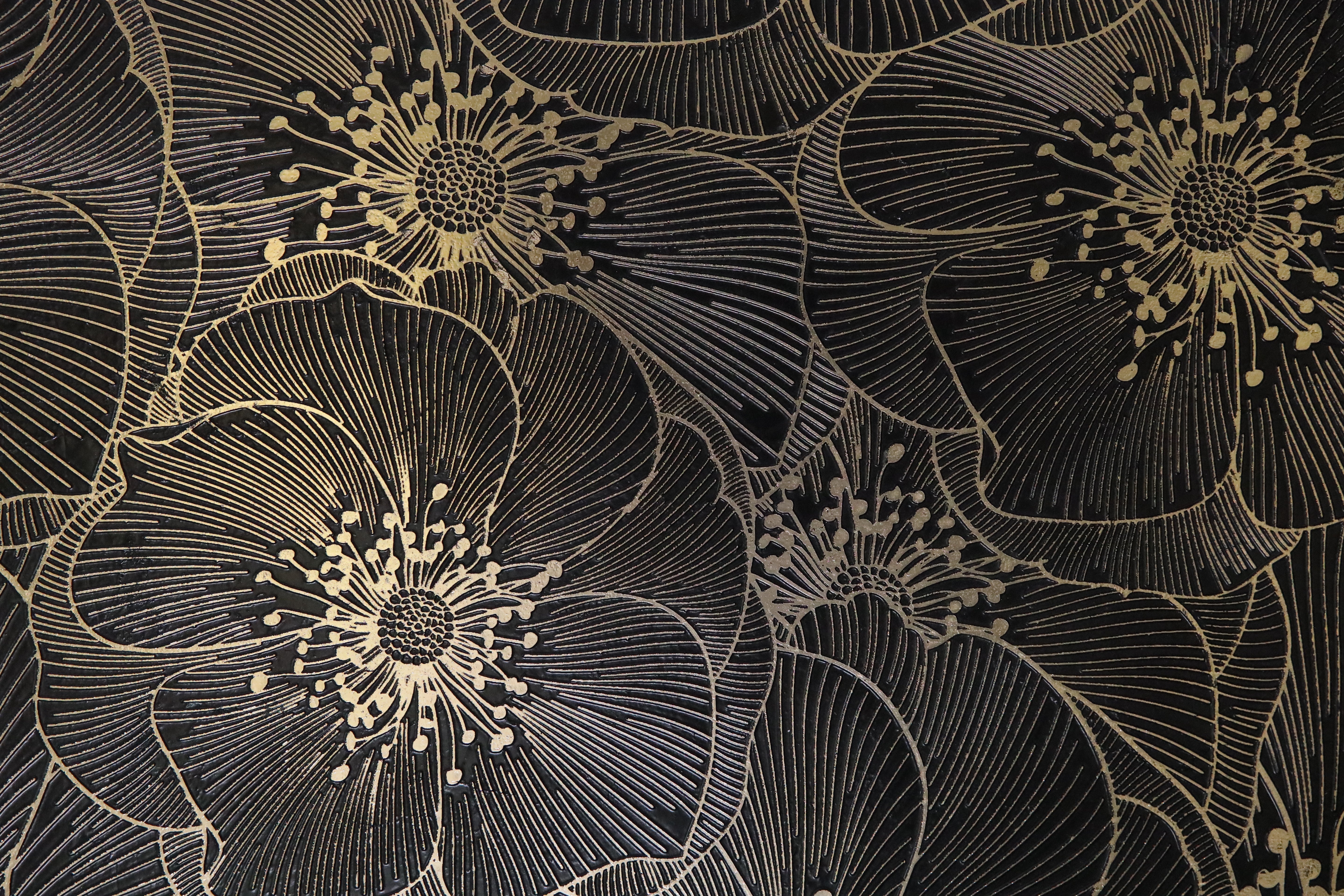 Close-up of Golden Blossom Nero decorative tile showing engraved floral detailing